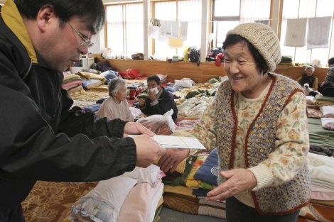 Una anciana recibe ayuda en Miyako. | AP Photo | Yomiuri Shimbun, Tetsuya Kikumasa