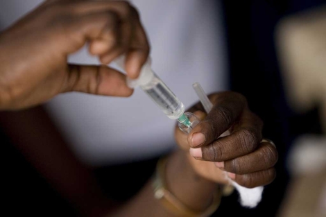 Una mujer prepara una vacuna en Kinshasa. | O. Asselin