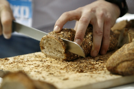 Un hombre corta una rebanada de pan artesanal. | Alberto di Lolli
