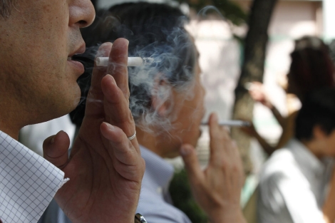 Personas fumando en Tokio. | Reuters