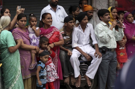 Varias jóvenes indias observan una fiesta religiosa. | AP
