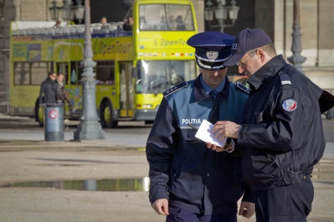 Un polica frnces muestra un mapa de Pars a un polica rumano. | AFP