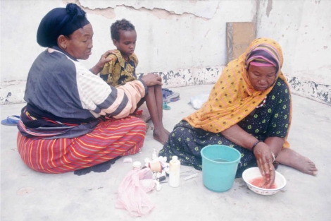 La abuela de una niña somalí se lava las manos tras la mutilación del clítoris. | AP