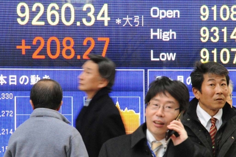 Ejecutivos que caminan frente a los resultados del ndice Nikkei en Tokio.| Efe | Everett Kennedy