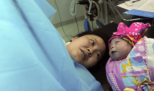 Una mujer observa a su beb recin nacido. | Reuters
