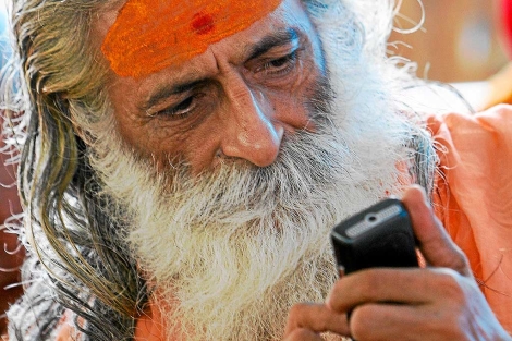 Un yogui consulta su móvil en la India.| Gurinder Osan