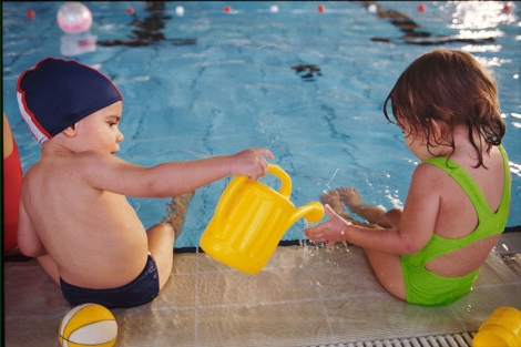 Dos nios juegan en el borde de una piscina. | Cati Cladera