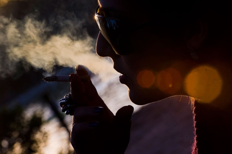 Una mujer fuma en el parque del Retiro. | Gonzalo Arroyo