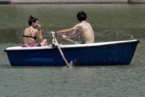 Unos jovenes pasean en barca en el parque del Retiro. | Alberto di Lolli