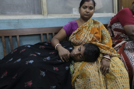 Un menor con fiebre espera para entregar una muestra de sangre en India. | Efe