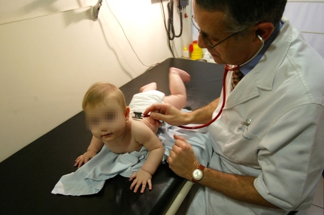 Un pediatra atiende a un bebé en su consulta