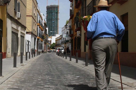 Un anciano camina por el barrio de Triana, en Sevilla