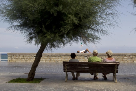 Ancianos sentados en un banco junto al Kursaal, en San Sebastin.