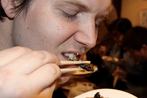 Un hombre comiendo insectos en Tokio (Japón).| Corbis
