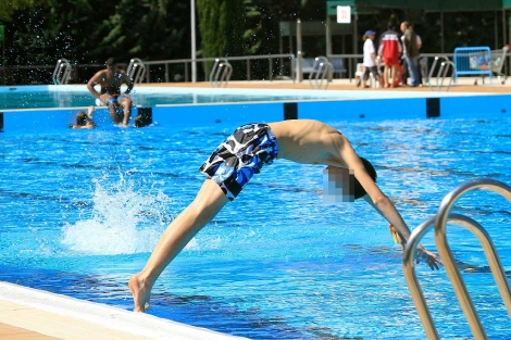 Un joven se zambulle en una piscina.| Víctor Lerena | Efe