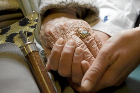 Una mujer coge de la mano a una anciana | Mundo