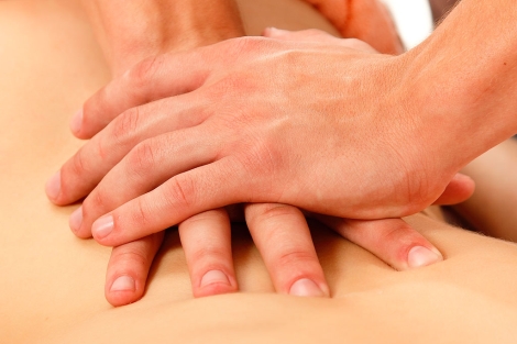 Un fisioterapeuta realiza un masaje de espalda.| EM