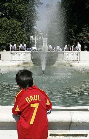 Un nio, con la camiseta de Ral, posa delante de una fuente. (Foto: EFE)