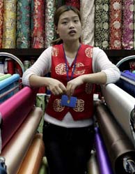 Una trabajadora rodeada de telas chinas en una tienda de Pekn, China. (Foto: EFE).
