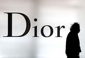 Una mujer camina junto a un logo de Dior en Shanghai (China). (Foto: AP)