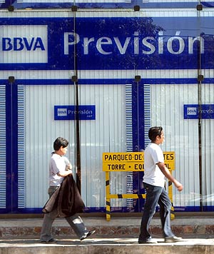 Unos bolivianos pasan por delante de la sede del fondo de pensiones Previsin. (Foto: EFE)