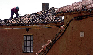 Un obrero reteja una vivienda, en Castrobol (Valladolid). (Foto: Carlos Espeso)