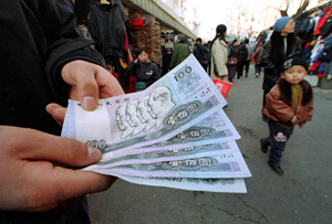 Un vendedor muestra billetes de Yuan en China. (FOTO: AP)