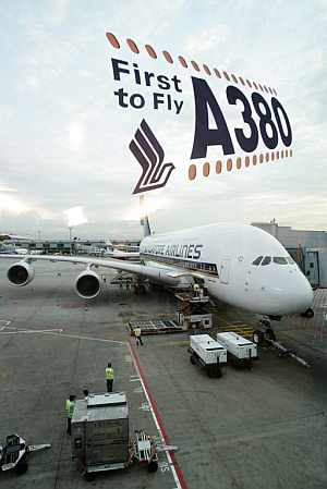 Operarios del aeropuerto preparan el A380 antes de su primer vuelo comercial. (Foto: AFP)