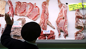 Un hombre observa el escaparate de una carnicera en un mercado de Vitoria. (Foto: EFE)