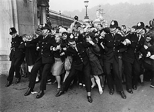 La polica intenta contener a los fans de los Beatles a su llegada al Palacio de Buckingham en 1965. (Foto: Hulton)