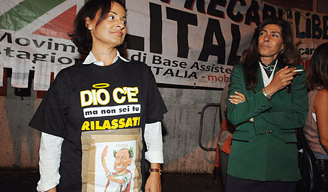 Una azafata, con una camiseta que ridiculiza a Berlusconi: "Dios existe, pero no eres t". (Foto: AFP)