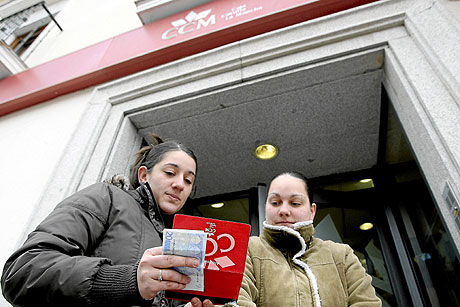 Una clienta de la caja saca dinero de una sucursal de Illescas (Toledo). | Jos Aym