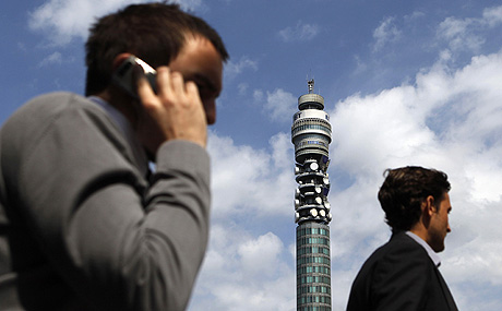 Dos hombres hablan por el mvil junto a una torre de British Telecom en Londres. | Reuters
