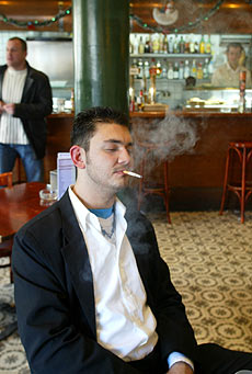 Un hombre fuma en un bar donde est permitido. | Antonio Moreno