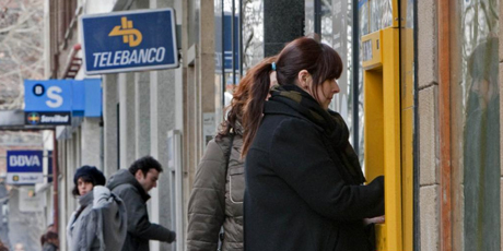 Una mujer saca dinero de un cajero automático. | Benito Muñoz