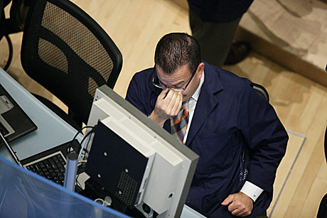 Un empleado de Wall Street descansa la vista durante su trabajo en la Bolsa de Nueva York. | Efe