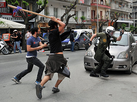 Dos manifestantes atacan a un policía en una de las movilizaciones de ayer. | Ap
