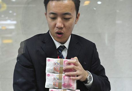 Un empleado bancario cuenta dinero en Shenyang. | Efe