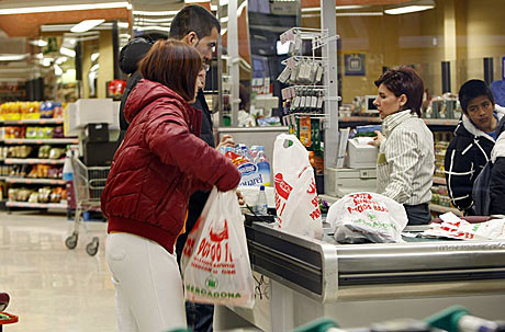 Una cajera atiende a dos clientes en un Mercadona de Valencia. | EL MUNDO