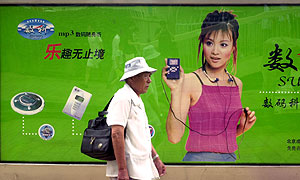 Un hombre pasea delante de un anuncio de reproductores de MP3. (Foto: AP)