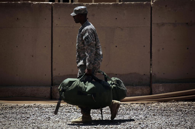 Un soldado porta sus maletas durante la retirada de las tropas. | Ap