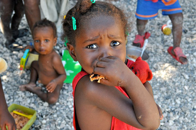 Una niña haitiana mira a la cámara durante una comida. | Rui Ferreira