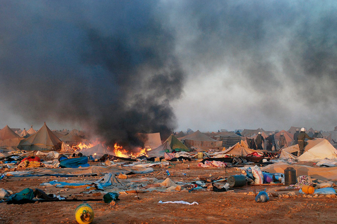 Humo y tiendas incendiadas tras el desmantelamiento del campamento saharaui. | Afp