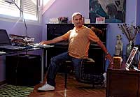 Junto a su piano y ante su ordenador, el actor se entrega al trabajo en su estudio de paredes violetas. / P. CARRERO