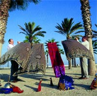 Dos miembros de una fil (comparsa de Moros y Cristianos) tienden al sol capas y atuendos, en la clebre playa de la Malvarrosa, Valencia.
