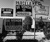 Carteles de venta agolpados en una finca de la periferia de Madrid. / DIEGO SINOVA