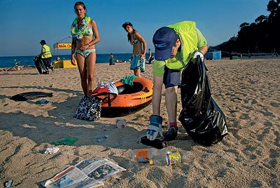 Despus de recoger envoltorios, envases, botellas, latas y otros desechos, Casariego (de verde y con gorra) es por un da uno de esos peones que contribuyen a que ondee la bandera azul y la de la «Q» de calidad en la playa de Lloret de Mar.