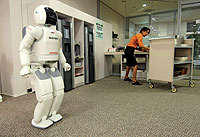 Asistente. Asimo es el robot con capacidad móvil más avanzada del mundo. Fabricado por Honda, en cuya sede en Tokio se le ve en esta imagen, puede agacharse, bailar, servir el café o correr a 6 km/h. Mide 1,30 metros porque más alto podría resultar intimidatorio.