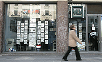 Una seora cruza ante ante la oficina de una empresa inmobiliaria intermediadora, en Madrid. (Foto: El Mundo)
