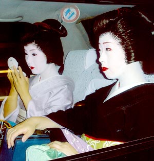 Unas geishas dndose los ltimos retoques en un taxi
